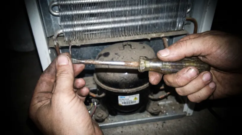Tangan teknisi menyervis kompresor chiller kecil